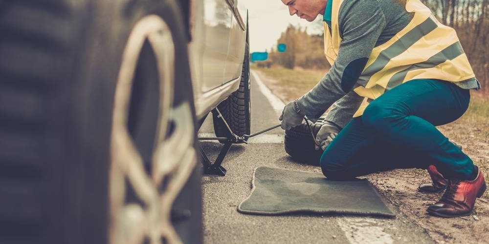 Man Changing Wheel On A Roadside